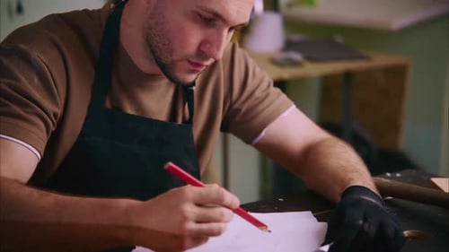 Carpenter Drawing Sketch on Paper in Workshop