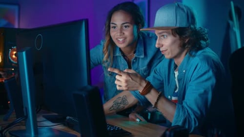 Happy young adults looking at computer screen at home