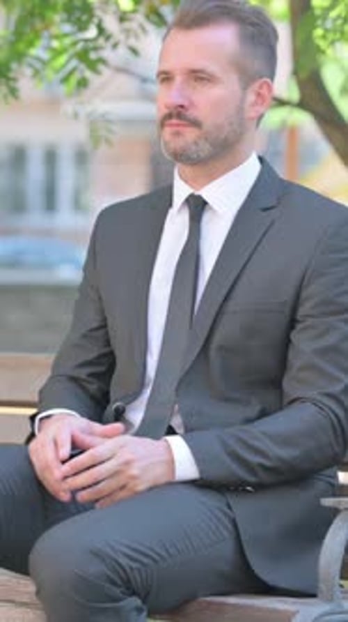 Empresário de meia idade saindo do banco no parque, vídeo vertical