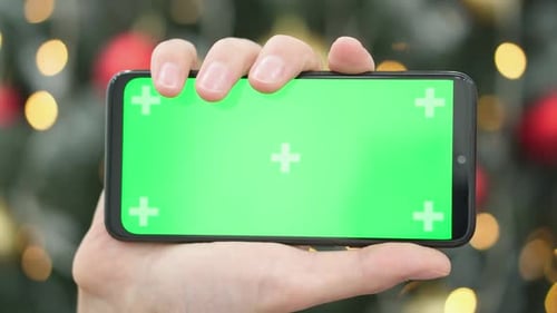 Hand Holding Smartphone with Green Screen on Chroma Key