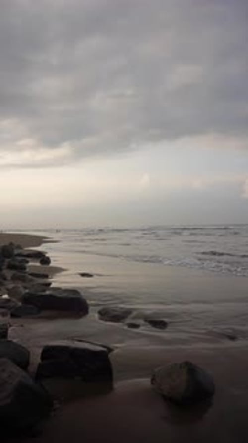 Beautiful vertical beach portrait video in the morning, beautiful view of small waves and beach