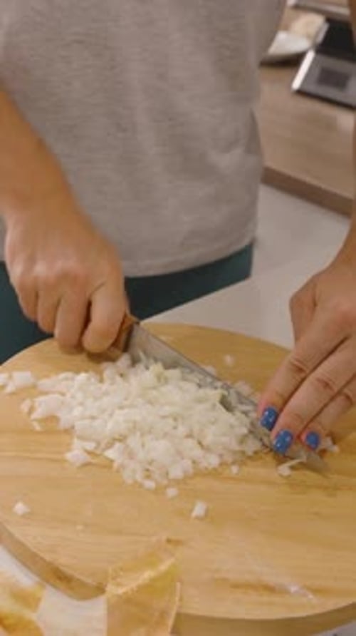 Vertical video. Woman Dicing Onion into Small Cubes on Round Board, Close Up Angle, Ingredient Prep