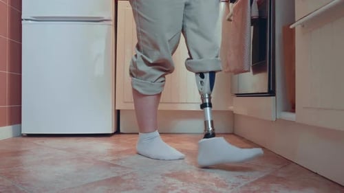 Long Cinematic Shot Beautiful Happy Woman with Bionic Cyber Prosthetic Leg Walks in Kitchen to Enjoy