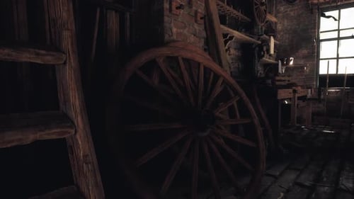 Old Wooden Wheel in a Rustic Workshop with Tools and Dim Lighting