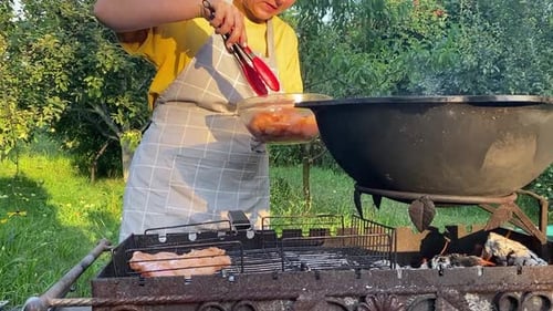 Woman Barbecuing Meat on Grill in a Yard