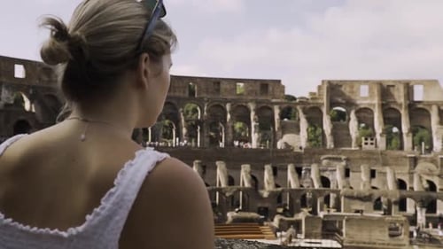 Female tourist looking out over Colosseum in Rome, Italy.