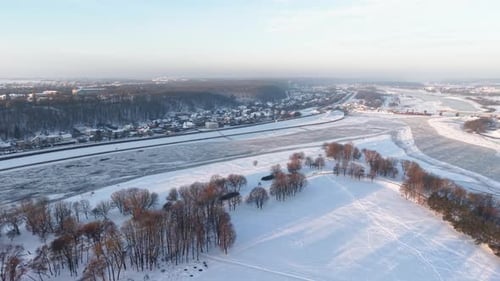 Aerial View of Snowy Landscape and Frozen River in Winter