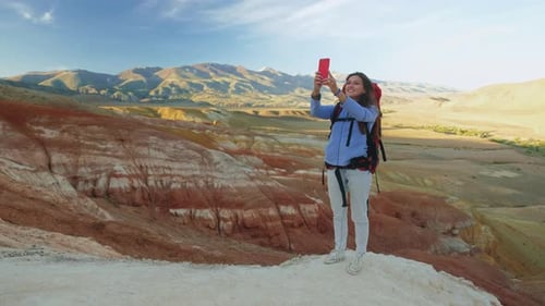 Climber on Top of the Mountain Takes a Photo Woman Traveler Takes a Photo on a Modern Smartphone