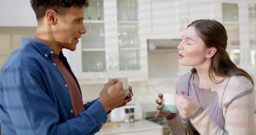 Couple Talking and Drinking Coffee in Kitchen
