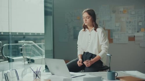 Young Female Architect Is Hard at Work in Her Office on Blueprints and Projects