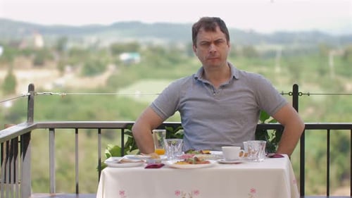 Man Having Breakfast Outdoors in Front of Mountain View