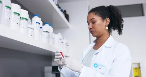 Female Lab Tech Examines Test Tube in Lab