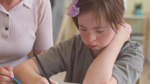 Child Drawing with Pencils Assisted by Adult