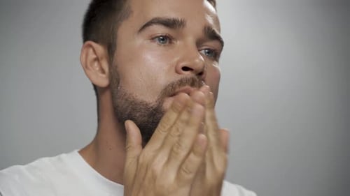 Man Applying Grooming Product to His Beard, Close-Up