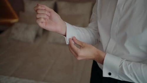 Man Adjusts Cuff Links on Shirt Sleeve Indoors