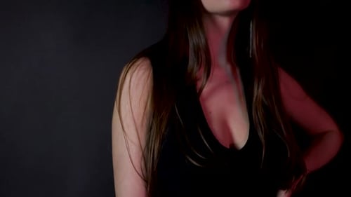 Stylish beautiful fashion female model posing in a dark studio in black dress