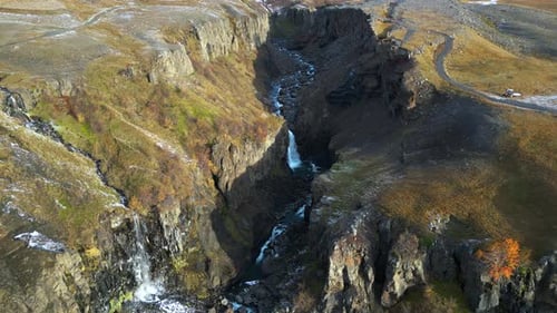 Waterfalls in Rocky Iceland Canyon at Base of Snowy Mountain, Aerial