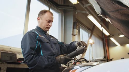 Car Mechanic Diagnosing Vehicle Engine With Computer