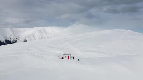 Refuge enneigé de Gainatu avec le pic Papusa dans les nuages, montagnes Iezer-Papusa, Arges, Roumanie, randonneur