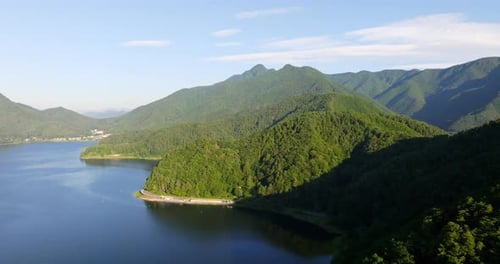 Drone flying along the mountainous coastline of lake Kawaguchi, summer in Japan