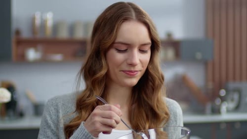 Smiling Woman Eating Healthy Salad in a Kitchen