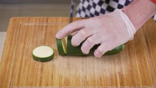 Slicing Fresh Zucchini on a Wooden Cutting Board