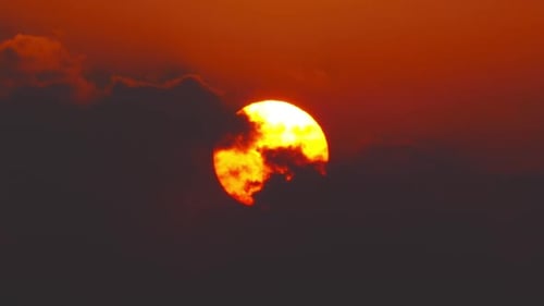 Aufgehende Sonne zwischen Wolken