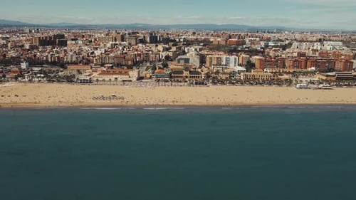 Aerial View of Bustling Coastal City and Expansive Beach on a Sunny Day
