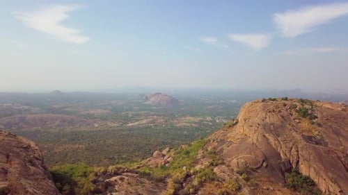 Forward moving drone shot capturing landscape of Ramanagara Hills on a clear sunny day in Karnataka,