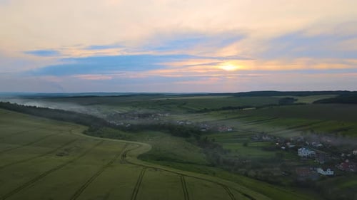 Rural Village Houses and Distant Green Cultivated Agricultural Fields with Growing Crops