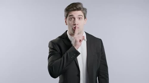 Gossiper Geschäftsmann Geste Of Shh Geheimes Schweigen Verschwörung Klatsch Gerüchte Hush on White Studio