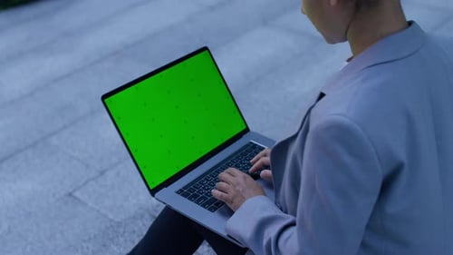 Woman Using Laptop with Green Screen Outdoors