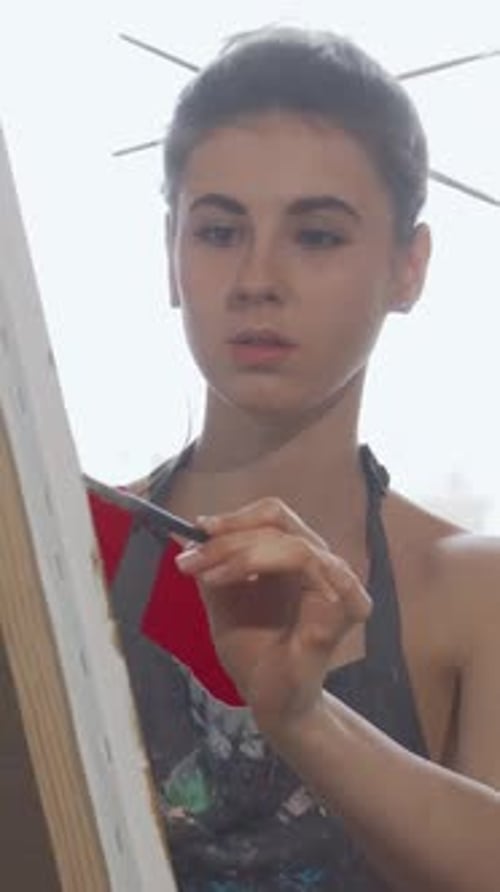 Elegant Woman Passionately Painting a Vibrant Masterpiece in Her Creative Workshop