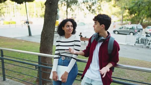 Smiling diverse young male and female university students in casual clothes with backpacks talking