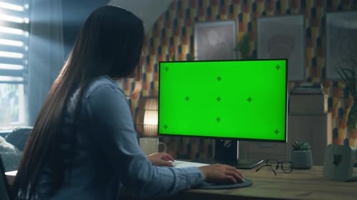 Woman Uses Computer with Green Screen in Home