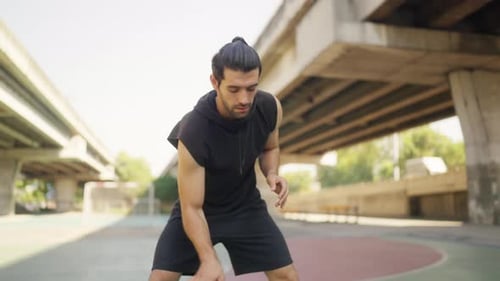 4K Caucasian man practice dribbling basketball on outdoors court.