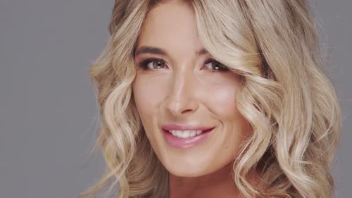 Studio Portrait of Young and Beautiful Blond Woman Over Grey Background Skin Care and Wellness