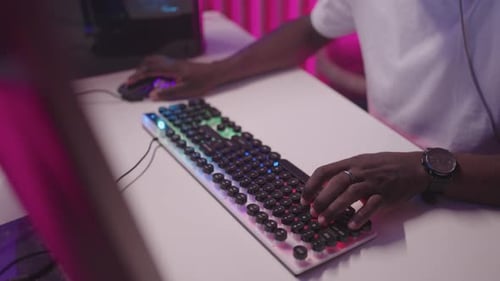 Person Using Computer Keyboard and Mouse at Night