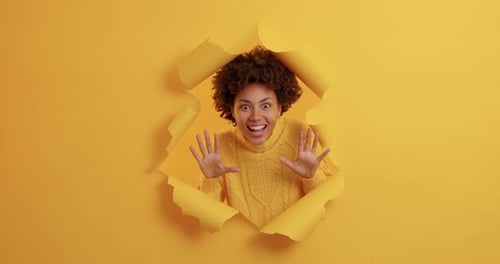 Excited Woman Posing in Ripped Yellow Background