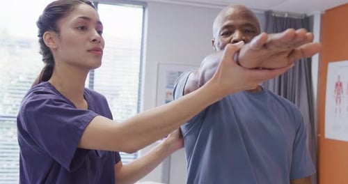 Healthcare Worker Helps Senior Patient With Arm Exercise