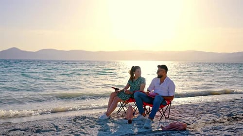 Young Couple Sitting On Beach