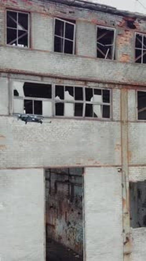 Aerial view of abandoned industrial buildings. Drone flies over an abandoned factory. Vertical video