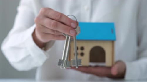 Real Estate Agent or Property Realtor Holding House Model and Giving Keys
