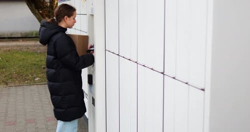 Young Woman Waits for Terminal to Verify Data and Unlock Appropriate Locker