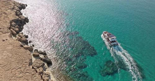 Vue aérienne d'un bateau à moteur flottant près des rochers de la mer bleue