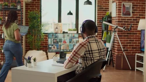 Man Participates in Video Conference from Home Office
