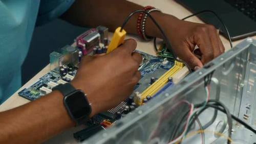 Hands of Technician Using Tools when Repairing Computer Motherboard