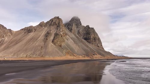 Vestrahorn mountains and black sand beach reflections in Iceland - drone aerial coastal view