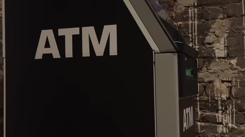 Automated Teller Machine ATM Located in an Urban Environment Complemented By a Stone Wall Background