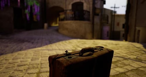 Rustic Suitcase Positioned on Cobblestone Path in Historic Town at Twilight